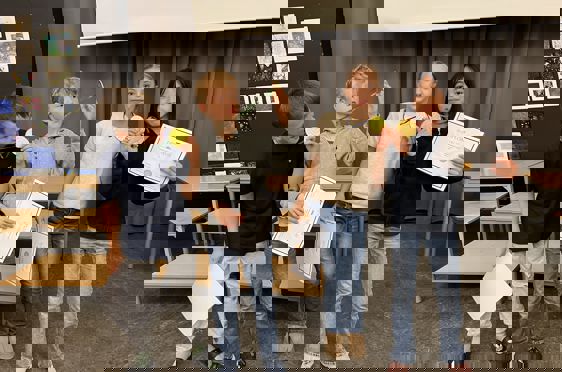 en gruppe mennesker som holder papirer